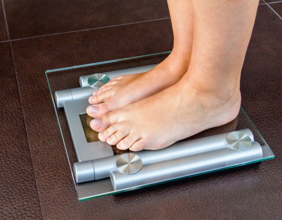Closeup of woman feet standing on bathroom scale