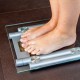 Closeup of woman feet standing on bathroom scale