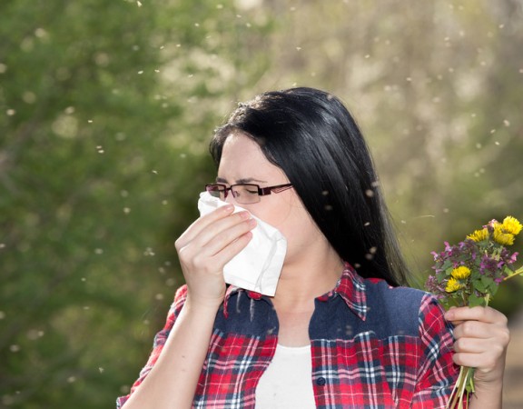 Girl having allergy and sneezing in tissue